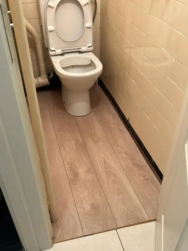Les mêmes toilettes après le débouchage : cuvette propre et sol nettoyé