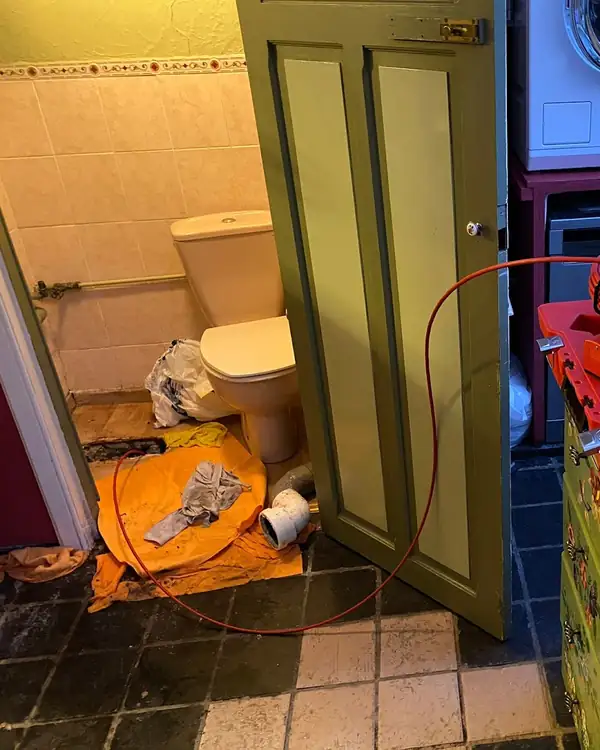 Toilettes pendant une intervention de MD Débouchage, avec le câble de la caméra d'inspection au sol